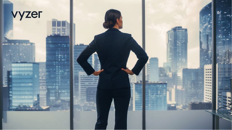 Image of a successful, strategic businesswoman in a stylish suit, looking over a bustling cityscape from her office window, symbolic of the market's resilience amid inflation and economic slowdown in 