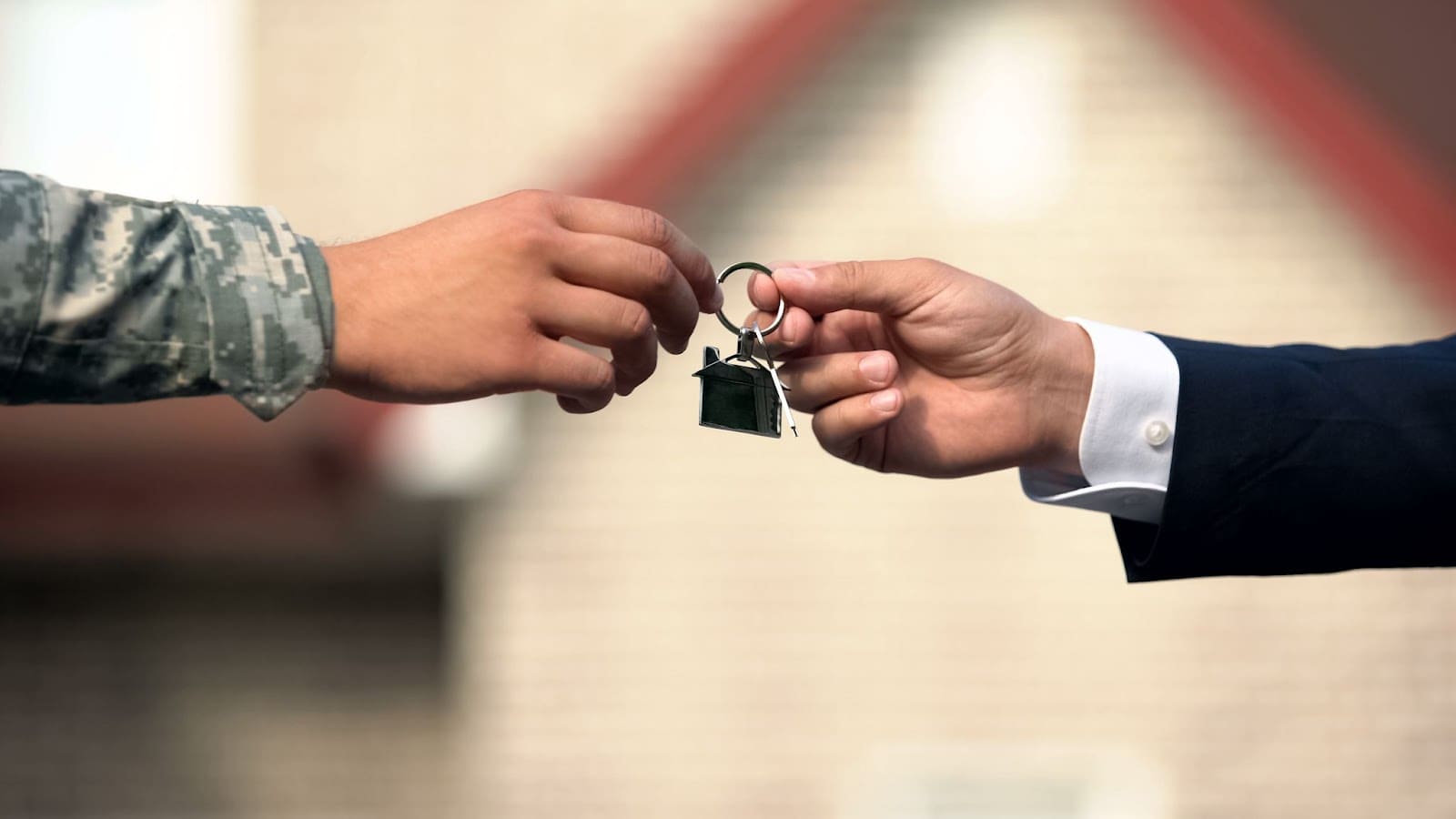 Businessman presents a house key to a military man - representing VA loans